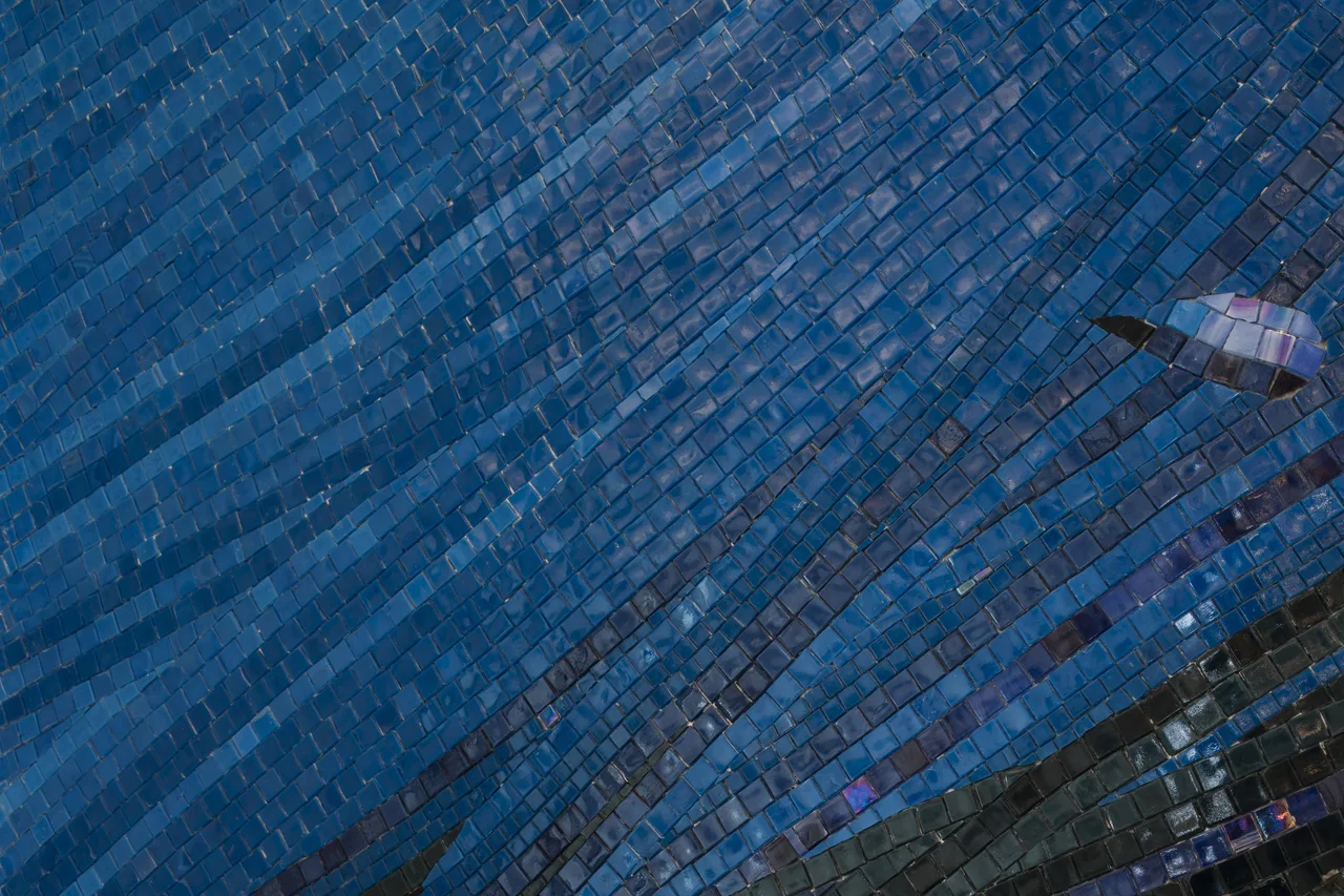 Textured blue-tile feature wall behind banquette, Level 22 restaurant