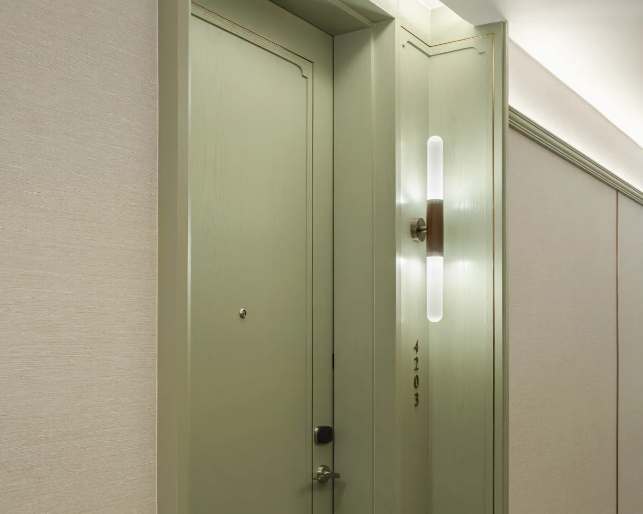 Eastin Grand Phayathai • High-zone Lift Lobby High-zone lift lobby – sage-green wall panels & bronze sconce